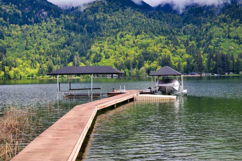 photo of 2 boat lifts with black canopies on lake in fall